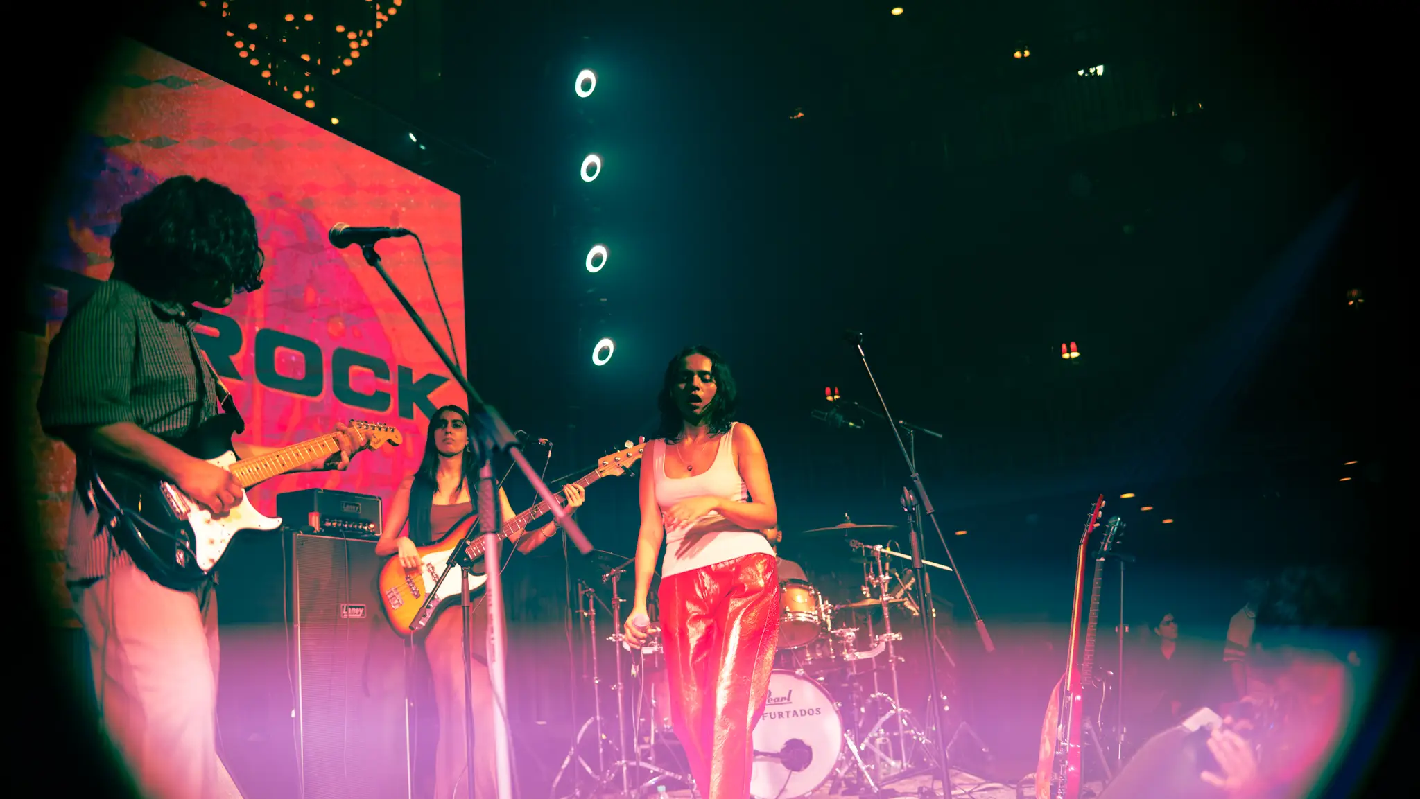 The band mid-set in red light, SALT ROCK on the big screen behind them